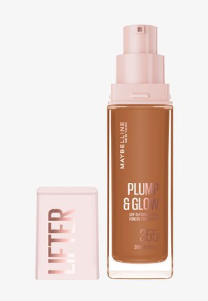 Maybelline Plump & Glow foundation, 30 ml, i en klar glasflaske med en lyserød pumpe, indeholder brun væske og modig tekst på etiketten.