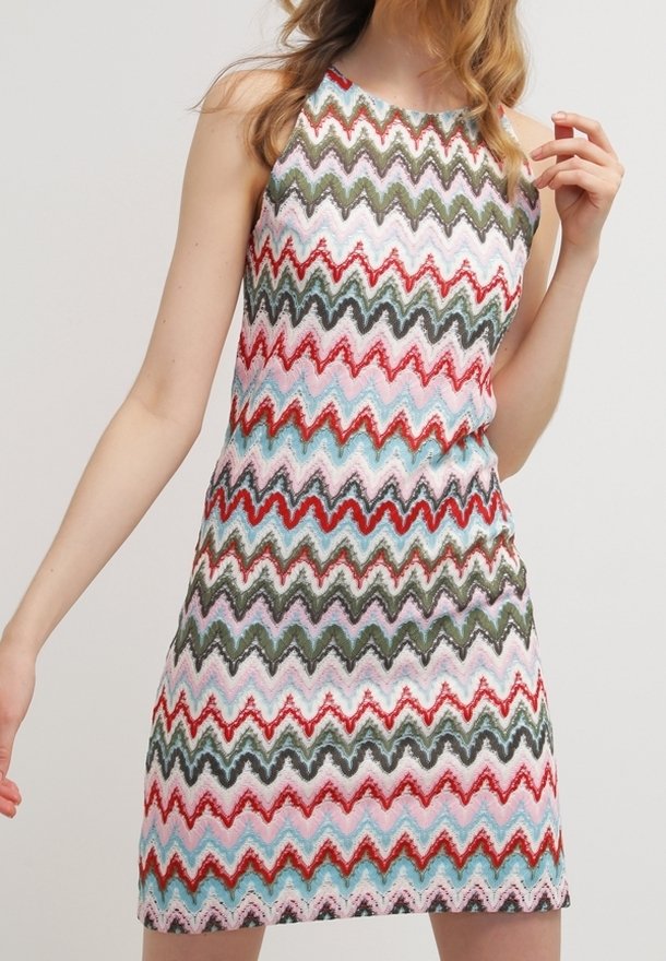 Robe sans manches à motif présentant un design en zigzag dans des tons rouge, vert, rose et bleu. Fabriquée en tissu texturé, coupe longueur genoux.