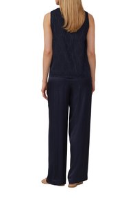Kombination aus navybluse ohne Ärmel mit strukturierten Blattmustern und navyfarbener weiter Hose. Der Stoff hat eine glatte, leicht glänzende Oberfläche.