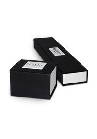 Des boîtes cadeaux noires, l'une rectangulaire et l'autre carrée, affichent des intérieurs blancs et des accents argentés avec le texte "REGENT" sur une plaque.