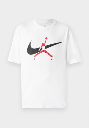 Weißes Baumwoll-T-Shirt mit einem großen schwarzen und roten Nike Swoosh-Logo und der Silhouette eines Basketballspielers. Kurze Ärmel, Rundhalsausschnitt.