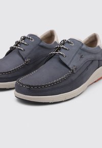 Zapatos de hombre en color marino, fabricados en cuero liso con costuras claras en contraste, cierre con cordones y una suela de goma texturizada.