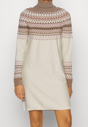 Beżowa sukienka swetrowa z brązowymi, różowymi i białymi geometrycznymi wzorami na piersi, rękawach i golfie.