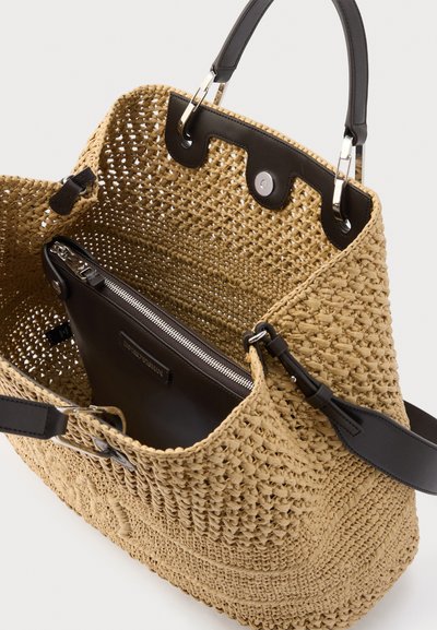 Μπεζ τσάντα χειρός από πλεκτό ψάθα με μαύρες δερμάτινες λαβές και αποσπώμενο μαύρο τσαντάκι με φερμουάρ στο εσωτερικό.