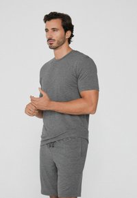 Camiseta de algodón gris y pantalones cortos a juego, diseño de cuello redondo, textura suave, estilo simple, detalles mínimos, corte relajado.