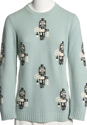 Jasnoniebieski sweter z dzianiny z powtarzającymi się postaciami robota w stylu pixel art w bieli i czerni na przodzie i rękawach. Żebrowane mankiety i dół.