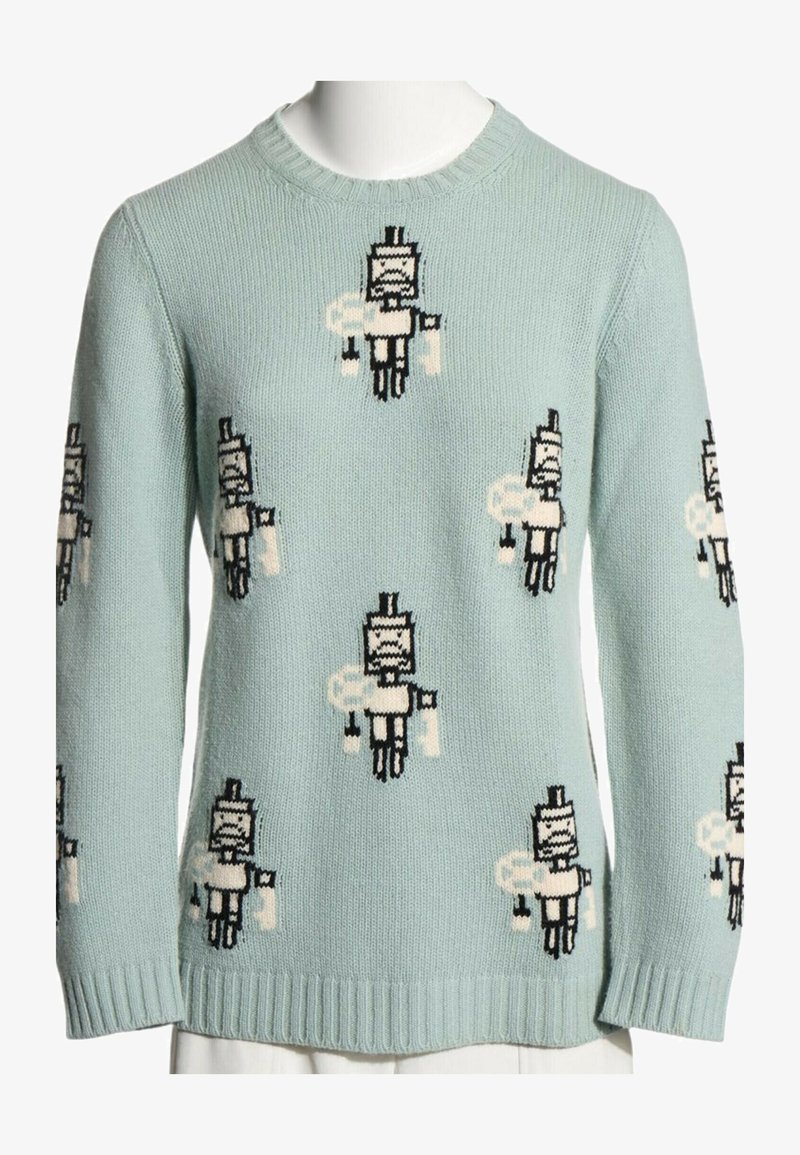 Pull en maille bleu clair avec des figures de robots en pixel art répétées en blanc et noir sur le devant et les manches. Poignets et bas côtelés.