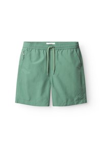 Zöld fürdőnadrág elasztikus derékpánttal, húzózsinórral és oldalsó cipzáras zsebbel. Könnyű, sima anyagból készült. Minta vagy díszítés nélkül.