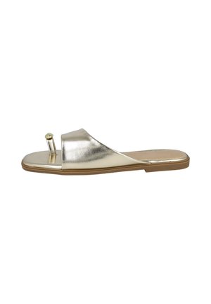 Sandalia plana tipo slide con tira metálica dorada y anillo para el dedo del pie sobre una suela marrón clara, vista de lado.