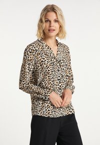 Skjorta med leopardmönster i beige och svart, med krage, långa ärmar och knäppning. Slät tyger med en glänsande yta.
