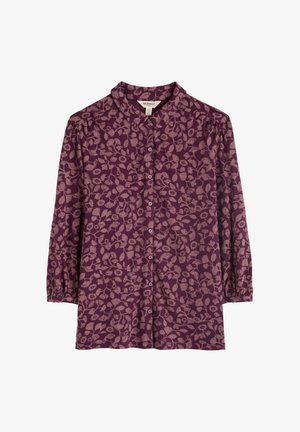 Blouse violette profonde à manches longues, avec un devant à boutons et un motif floral rose clair. Tissu doux avec un col.