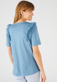 Blauw T-shirt met korte mouwen, gemaakt van zachte katoen, met rimpelige kantdetails op de schouders en een relaxed fit.