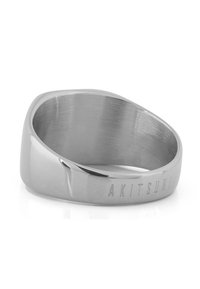 Silver metal ring with a smooth, polished surface and an angled design. Features engraved "AKITSUNE" detail on the band.