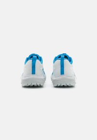 Baskets de sport blanches avec des accents bleus, présentant une semelle texturée, des onglets de talon renforcés et un dessus en maille pour la respirabilité.