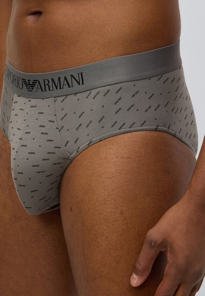 Γκρι βαμβακερά εσώρουχα με μαύρη ελαστική μέση που φέρει το λογότυπο «Emporio Armani» και μικρό επαναλαμβανόμενο λογότυπο στο ύφασμα. Μαλακή υφή, εφαρμοστή γραμμή.