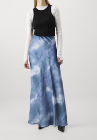 Maximeckor sininen ja valkoinen abstrakti kuvio, mustalla istuvalle yläosalle ja pitkille valkoisille hihoille. Valmistettu sileästä kankaasta, jossa on virtaava siluetti.