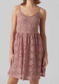 Vestido de encaje en rosa suave, con escote en V, tirantes ajustables, falda acampanada y patrones de diamante intrincados en todo el vestido.