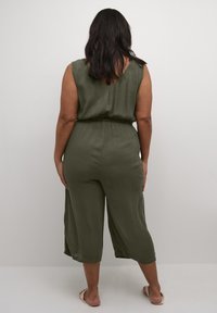 Olive green jumpsuit with a V-neck, elastic waist, and cropped wide-leg design. Soft texture and smooth fabric; back view shown.