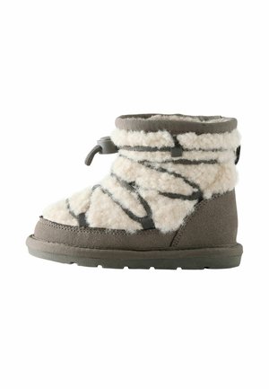 Botte d'hiver grise pour enfant avec doublure en fausse fourrure beige, lacets élastiques croisés et fermeture réglable par un bouton-pression sur fond blanc.
