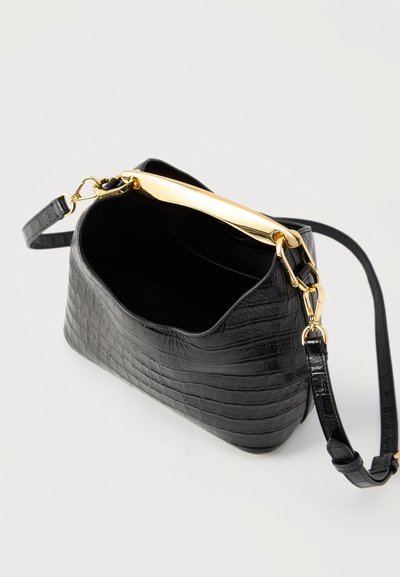 Μαύρη δερμάτινη τσάντα με ανάγλυφο μοτίβο κροκό, αφαιρούμενο ιμάντα ώμου και λαμπερή χρυσή μπάρα, εμφανίζεται ανοιχτή σε λευκό φόντο.