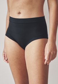 Czarne figi z wysokim stanem wykonane z gładkiego materiału, wyposażone w szeroką, wygodną gumę oraz bezszwowe krawędzie dla eleganckiego wyglądu.