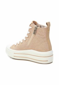 Zapatillas altas de textil en beige claro con cordones blancos, un zipper lateral y suela blanca con rayas beige en contraste.