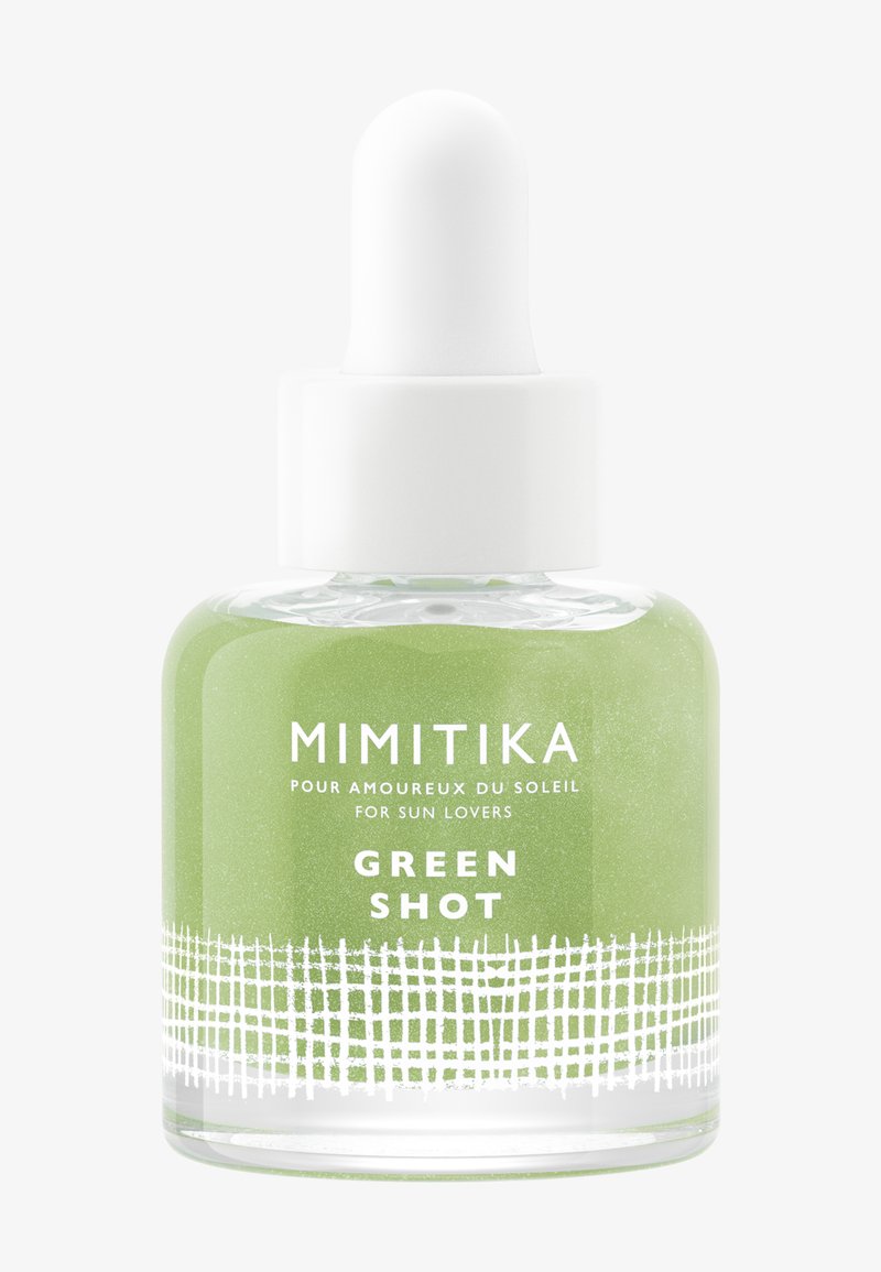 Bottiglia contagocce in vetro etichettata Mimitika Green Shot con liquido verde e design bianco testurizzato nella parte inferiore della bottiglia.