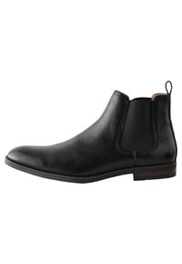 Zwarte leren Chelsea-laars met elastische zijkanten, afgeronde neus, trekband aan de hiel en een contrasterend houtpatroon op de zool.