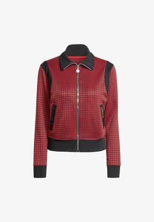 Red and black zip-up jacket with houndstooth pattern, ribbed collar and cuffs, and side pockets. Made of textured fabric with black accents.