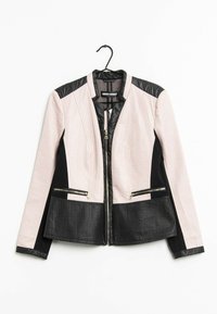 Veste pour femmes avec un haut texturé rose et des accents en cuir noir, poches zippées et un design ajusté. Accrochée à un crochet.