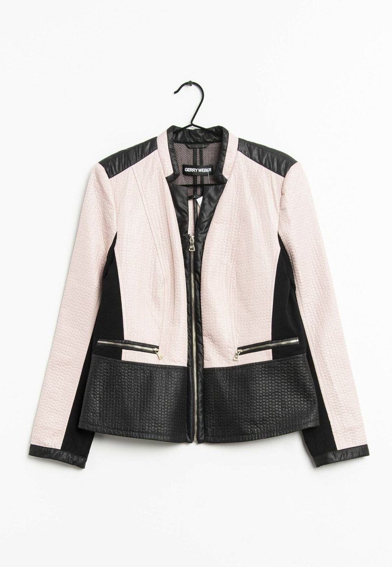 Veste pour femmes avec un haut texturé rose et des accents en cuir noir, poches zippées et un design ajusté. Accrochée à un crochet.