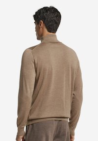 Brauner Pullover mit hohem Kragen, langen Ärmeln, glatter Textur und gerippten Bündchen, von hinten betrachtet. Einfaches, minimalistisches Design.