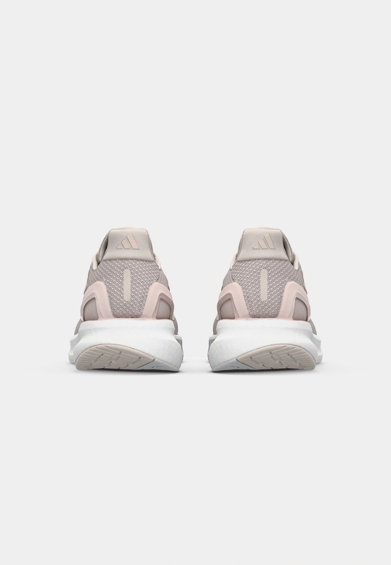 Baskets de sport rose clair avec une tige en mesh, un col rembourré et une semelle intermédiaire blanche. Marquage notable à trois bandes à l'arrière.