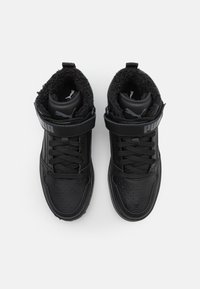 Černé vysoké tenisky s hladkým koženým povrchem, perforovanými detaily, fleecovou podšívkou a suchým zipem. Na popruhu je logo Puma.