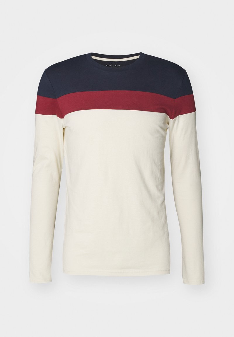 Long-sleeve crewneck shirt with cream base, wide red stripe below navy blue yoke across chest and shoulders.