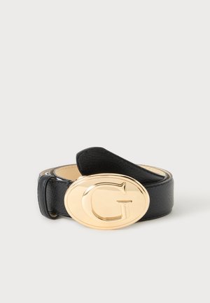Ceinture en cuir noir enroulée avec une grande boucle ovale dorée présentant une lettre G en relief et un petit logo "Guess".