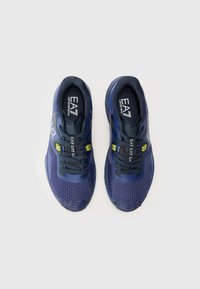 Navy running shoes with a mesh upper, textured sole, and yellow accents. Features laces and branding on the tongue and side.