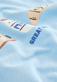 Sininen teksturoitu kangas, jossa on leikillisiä jäätelötötterö- ja maitopurkki-kuvioita, vastavärisellä kirjailulla teksti "GREAT."