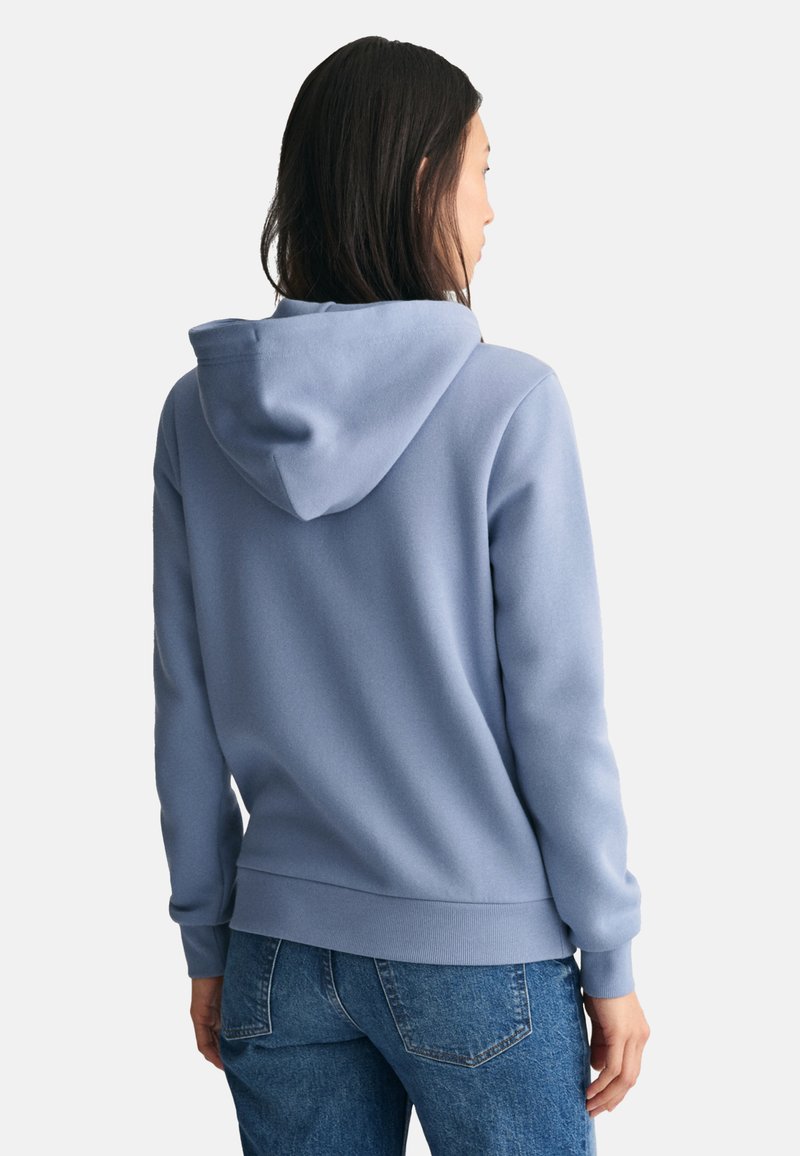 Hoodie in lichtblauw, met een zachte textuur, ribbelmanchetten en -zoom, in een relaxte fit. Zichtbare stiksels en details van de capuchon.