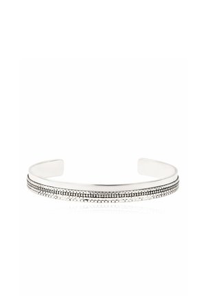 Bracelet manchette en argent avec un motif à double ligne texturé le long de la surface extérieure, ouvert aux extrémités pour un ajustement réglable.