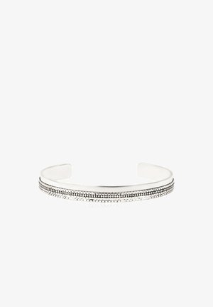 Bracelet manchette en argent avec un motif à double ligne texturé le long de la surface extérieure, ouvert aux extrémités pour un ajustement réglable.