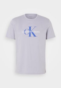 Light lavender short-sleeve T-shirt made of cotton, featuring a large blue "CK" logo and "Calvin Klein Jeans" text on the front.