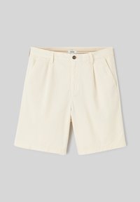Short beige sur mesure longueur genou avec passants de ceinture, poches latérales, plis devant et fermeture par un seul bouton marron.