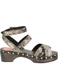 Strappy sandals featuring a snake print design, black straps, a chunky wooden heel, and gold studs along the sole's edge.
