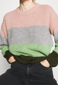 Maglione lavorato a maglia con un design a blocchi di colore in strisce rosa, grigio, verde e verde scuro. Vestibilità comoda con polsini e orlo a coste.