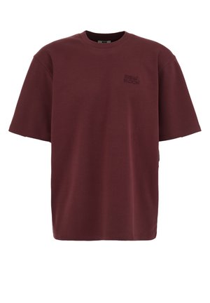T-shirt oversize à manches courtes couleur bordeaux avec col ras du cou et petit logo "Urban Bloom" brodé sur le côté gauche de la poitrine.