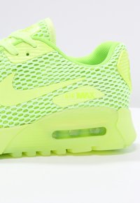 Light green Nike Air Max sneaker with mesh upper, visible air cushioning, and laces, shown from the side on a white background.