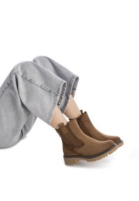 Botas de tobillo de ante marrón con paneles laterales texturizados y inserciones de malla, que cuentan con una suela de goma gruesa y detalles en costura.