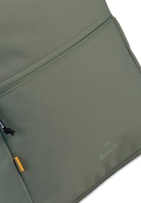 Groene Textuurstof rugzak met een voorzak met rits, voorzien van een zwarte koord en een kleine oranje accenten. Het merklogo is zichtbaar.