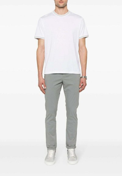 T-shirt bianco a maniche corte abbinato a pantaloni chinos grigio chiaro, completato da sneakers grigio chiaro. Design semplice e pulito con colori neutri.
